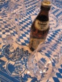 Bierflasche und sechs Gläser auf bayerischem Tischtuch