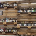 Aufgereihte Bierflaschen an einer Wand aus Holzpaletten